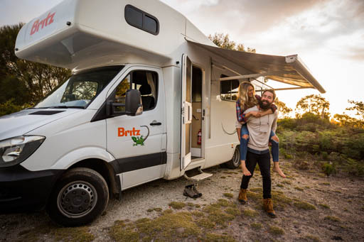 Britz motorhome with couple playing outside