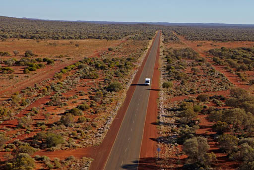 Wide open road with arial view of a camper on a straight road in the Outback