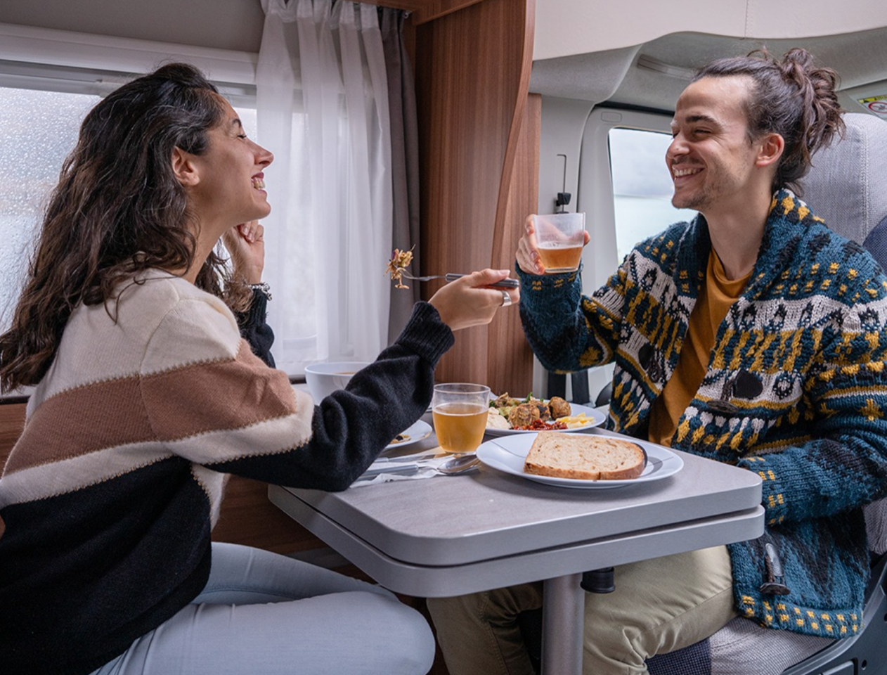 couple enjoying a meal in thier bunk campers campervan hire