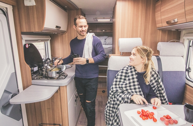 man and woman cooking in their motorhome