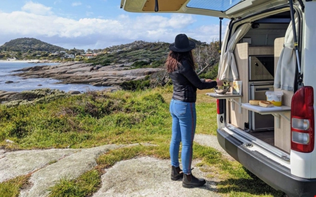 woman outside apollo motorhome cooking