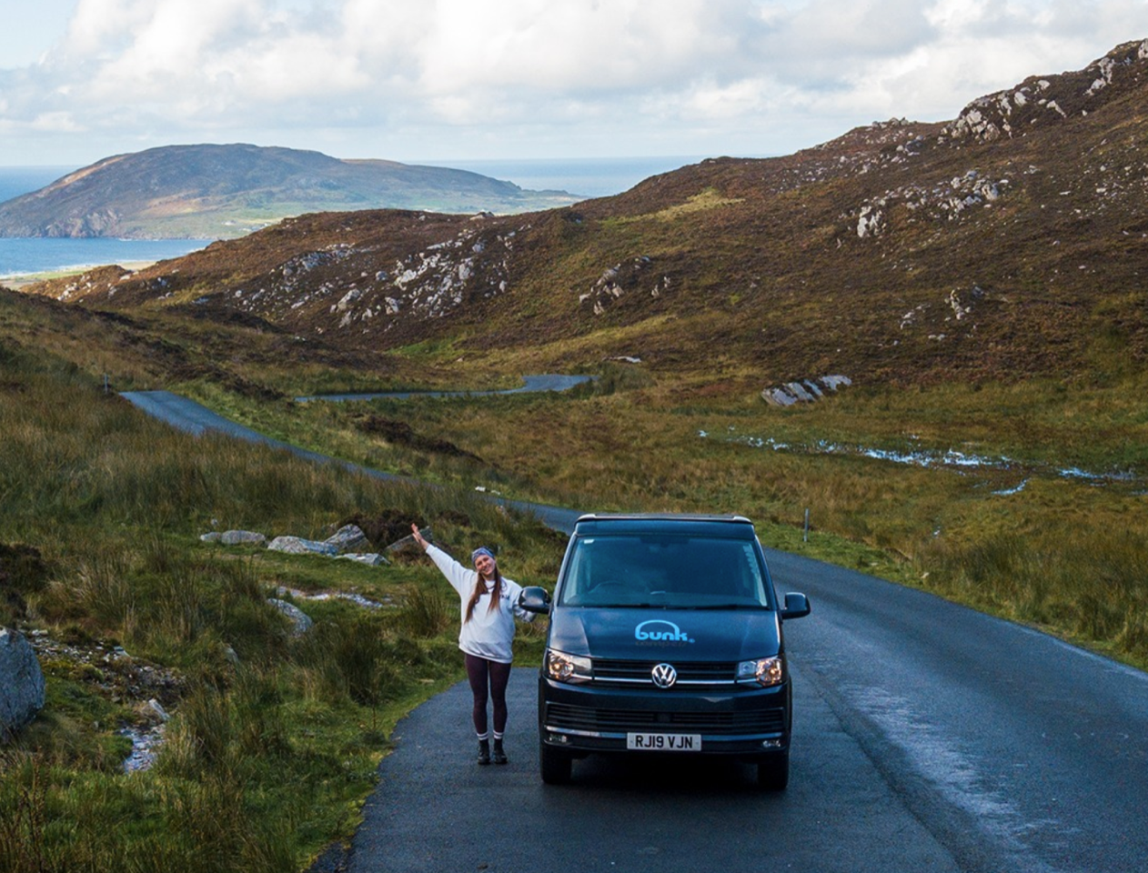 woman waving next to her bunk campervan hire